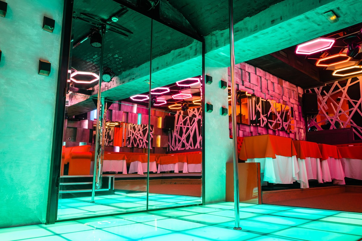 Night club interior with pole dance stage with neon lights no people