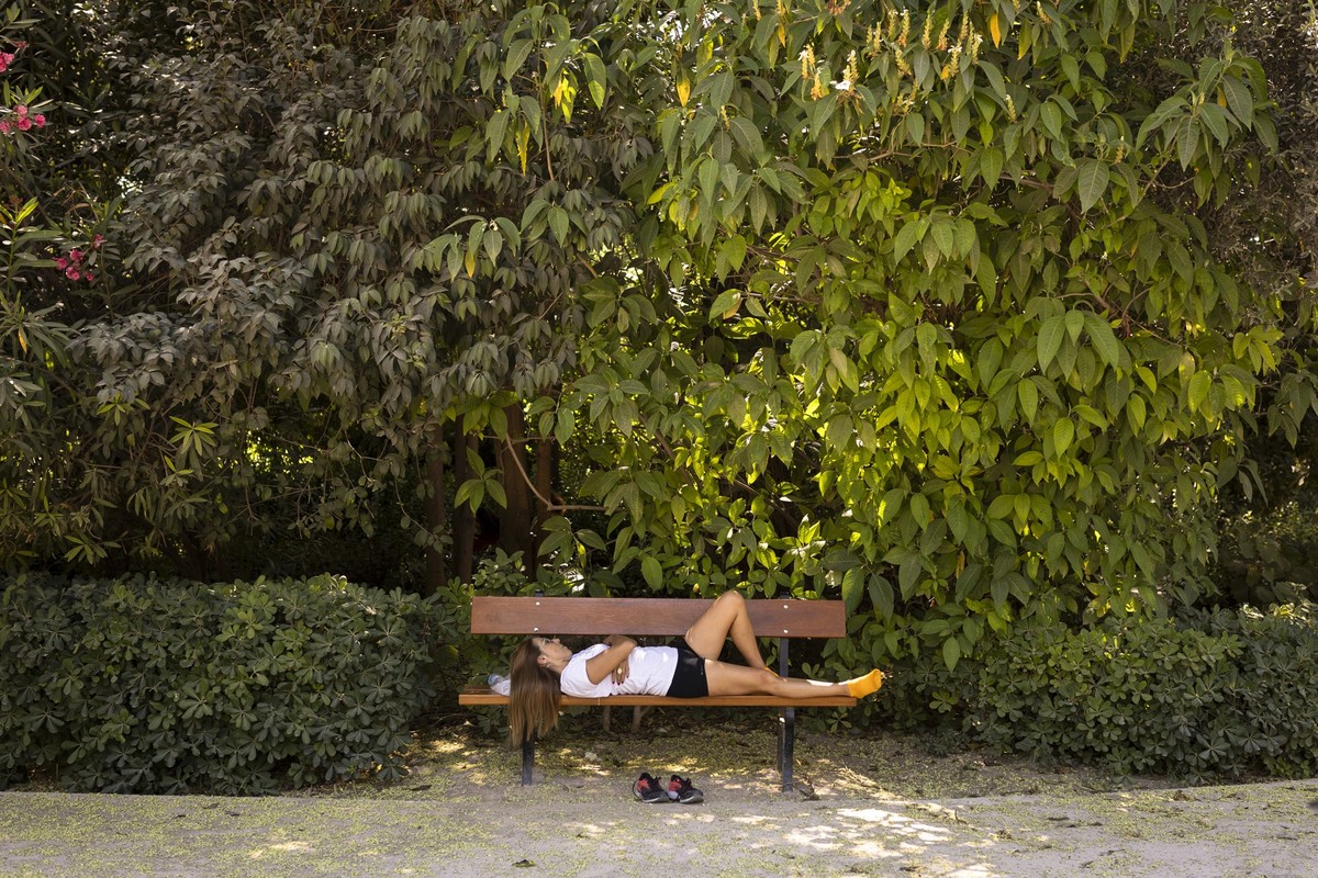 18.06.2024, Griechenland, Athen: Eine Frau ruht sich auf einer Bank im Schatten im Nationalgarten aus. Griechenland ist in diesem Jahr besonders früh von großer Hitze betroffen: Meteorologen zufolge w ...