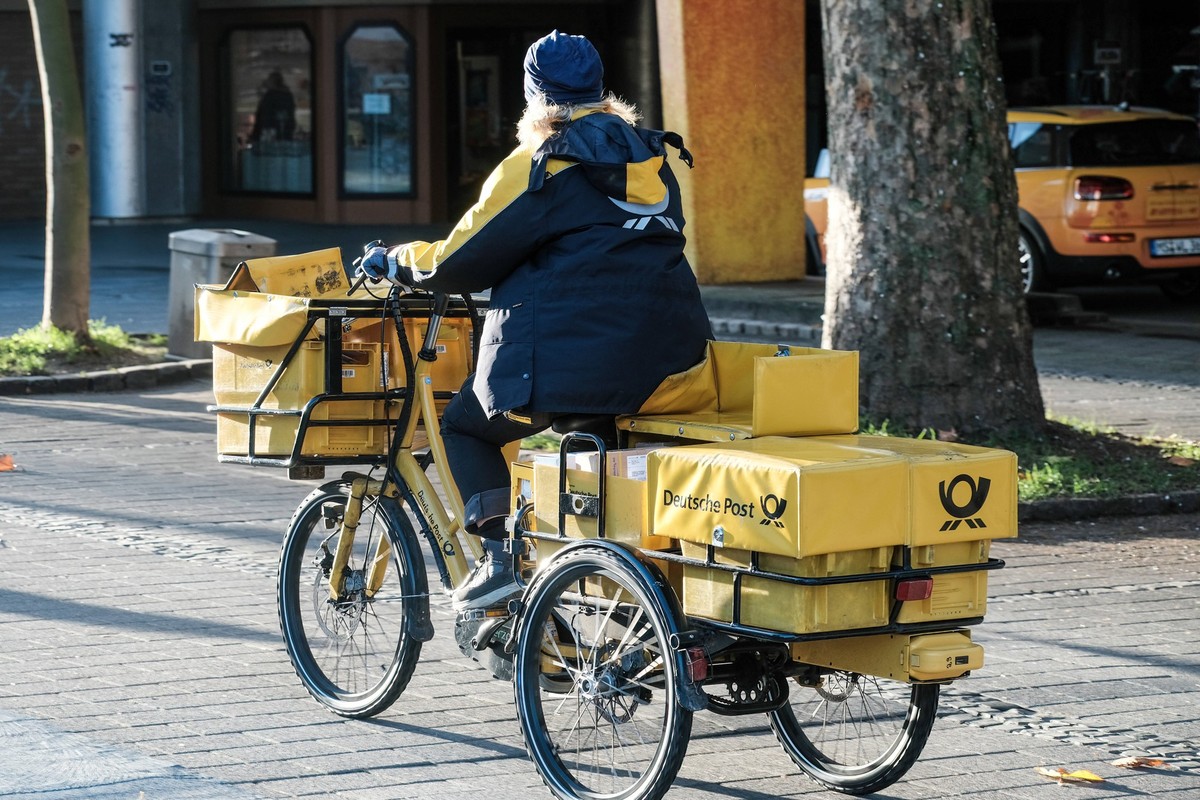 Düsseldorf 23.11.2022 Deutsche Post DHL Brief Briefe Briefzustellung Zusteller Briefpost Posthorn Postbote Postzusteller Briefzusteller Trolley Postkarre Postwagen Lastenfahrrad Lastenrad Elektrorad E ...