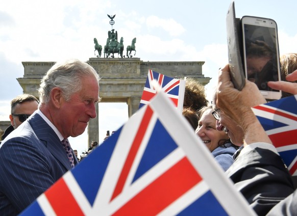 ARCHIV - 07.05.2019, Berlin: Der damalige britische Prinz Charles spricht zwischen britischen F�hnchen mit Schaulustigen am Brandenburger Tor bei seinem Besuch im Mai 2019. K�nig Charles III. wird vom ...