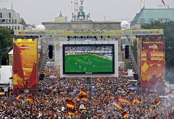 ARCHIV - 30.06.2006, NA, Berlin: Tausende Zuschauer verfolgen auf der Fanmeile am Brandenburger Tor in Berlin das WM-Fu�ballspiel zwischen Deutschland und Argentinien. Das Jahr 2006 hat die Fu�ballwel ...