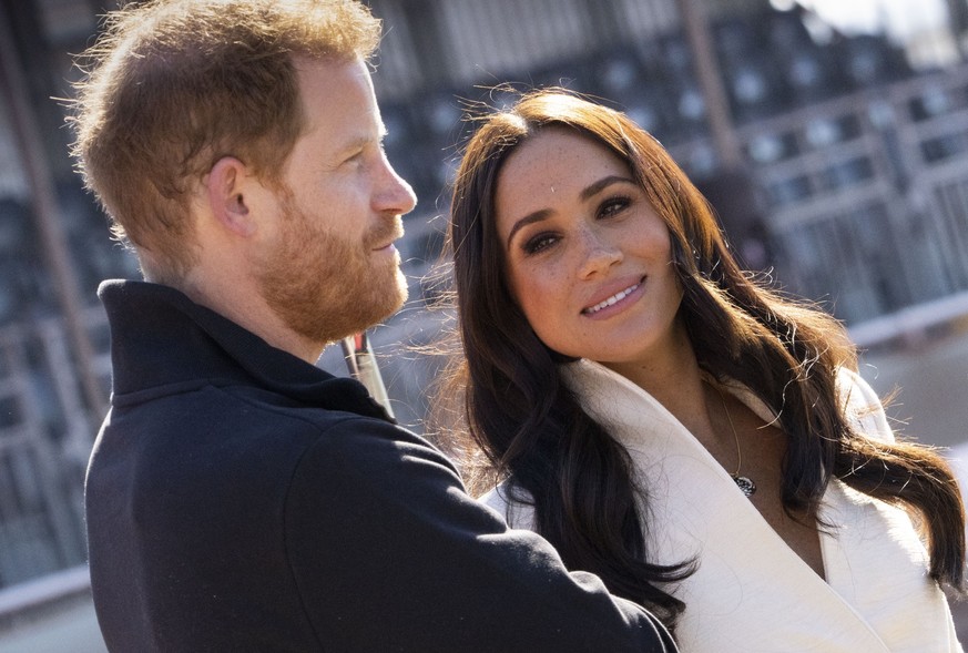 ARCHIV - 17.04.2022, Niederlande, Den Haag: Prinz Harry, Herzog von Sussex, und Meghan, Herzogin von Sussex, nehmen an den Leichtathletikwettbewerben der Invictus Games 2022 im Zuiderpark teil. Der br ...