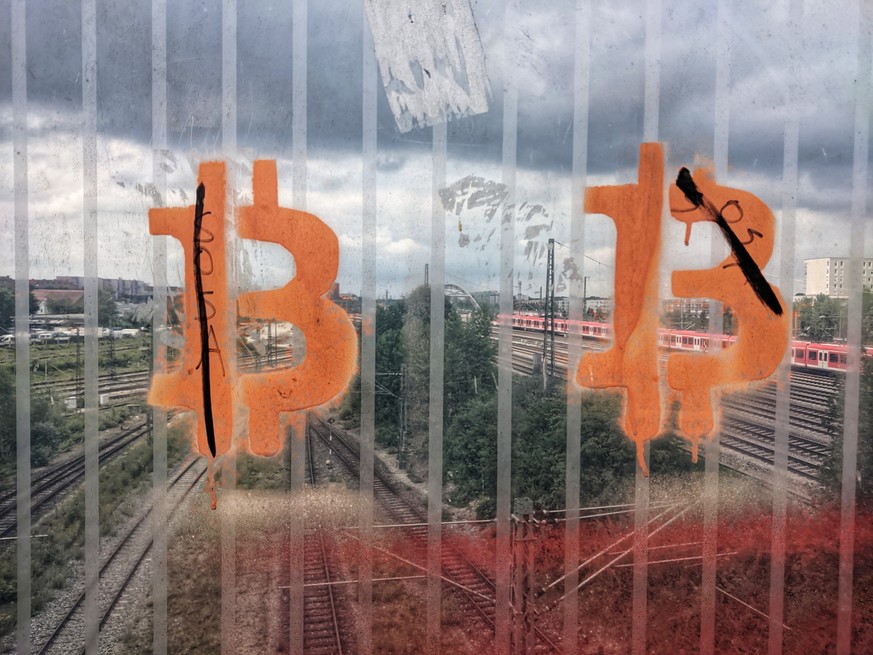 Ein Bitcoin-Graffitti ziert eine Scheibe in München.