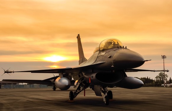 f16 falcon fighter jet in the base on sunset background