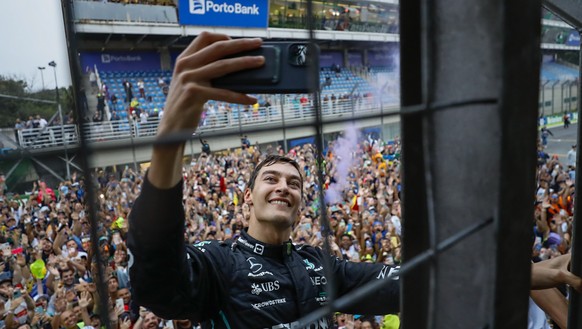 Mercedes driver George Russell, of Britain, takes a selfie with fans after winning the Brazilian Formula One Grand Prix, at the Interlagos race track in Sao Paulo, Brazil, Sunday, Nov. 13, 2022. (AP P ...