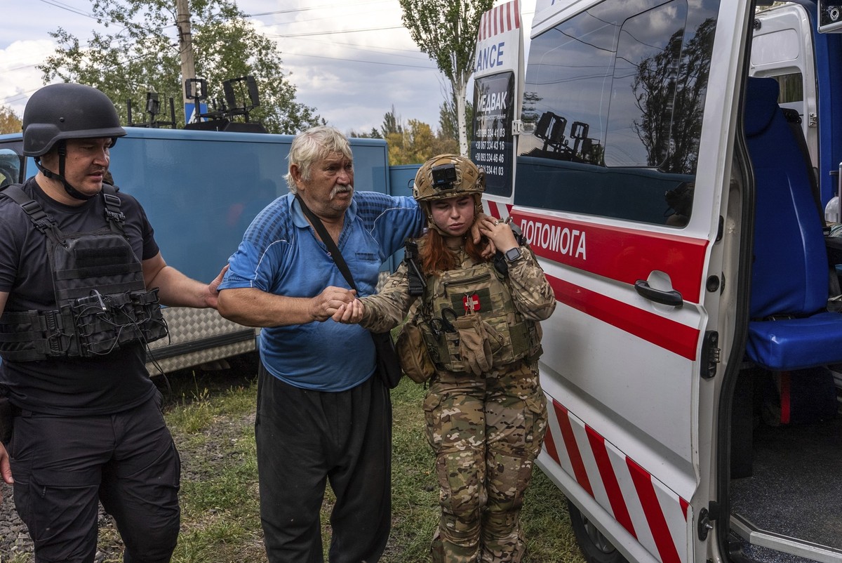 Police officers help Mykola Puzyk, 70, who lost his wife Tetiana Puzyk, 68, to move from an armored car to a ambulance from the village of Yarova, that was hit by Russian aerial strike, which killed d ...
