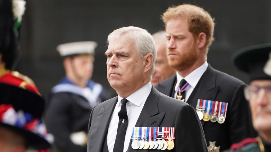 ARCHIV - 19.09.2022, Großbritannien, London: Prinz Andrew, Herzog von York (l), und der Herzog von Susssex, Prinz Harry (dahinter) kommen zum Staatsakt vor der Beisetzung von Königin Elizabeth II. in  ...
