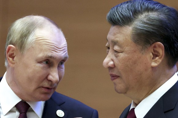 Russian President Vladimir Putin, left, speaks to Chinese President Xi Jinping during the Shanghai Cooperation Organization (SCO) summit in Samarkand, Uzbekistan, Friday, Sept. 16, 2022. (Sergei Bobyl ...