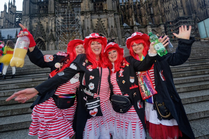 11.11.2023, Nordrhein-Westfalen, Köln: Eine Gruppe feiernder Menschen posiert zum Auftakt der Karnevalssession vor dem Dom für ein Foto. Foto: Henning Kaiser/dpa +++ dpa-Bildfunk +++