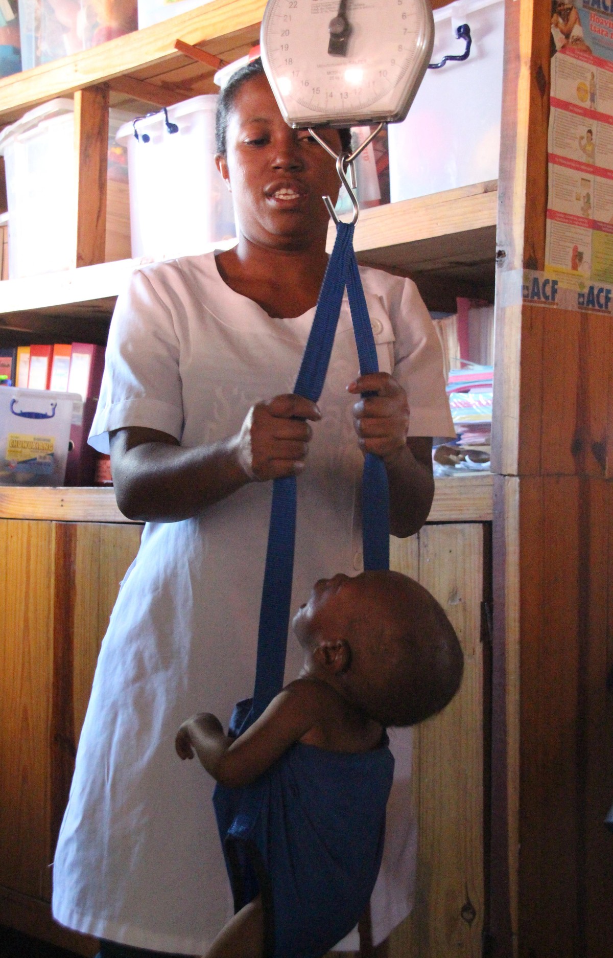 A social worker weighs a malnourished child in the nutrition centre by the aid organisation Action contre la Faim in a slum of Antananarivo, Madagaskar (Africa). Thousands of children in Madagascar di ...