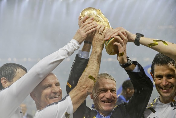 FILE - In this Sunday, July 15, 2018 file photo, France head coach Didier Deschamps, second right, holds the trophy at the end of the final match between France and Croatia at the 2018 soccer World Cu ...