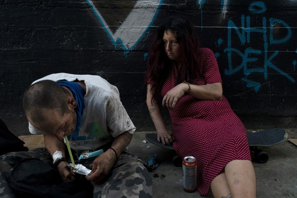 Jenn Bennett, who is high on fentanyl, sits on her skateboard with a visible black eye as her friend, Jesse Williams, smokes the drug in Los Angeles, Tuesday, Aug. 9, 2022. Use of fentanyl, a powerful ...