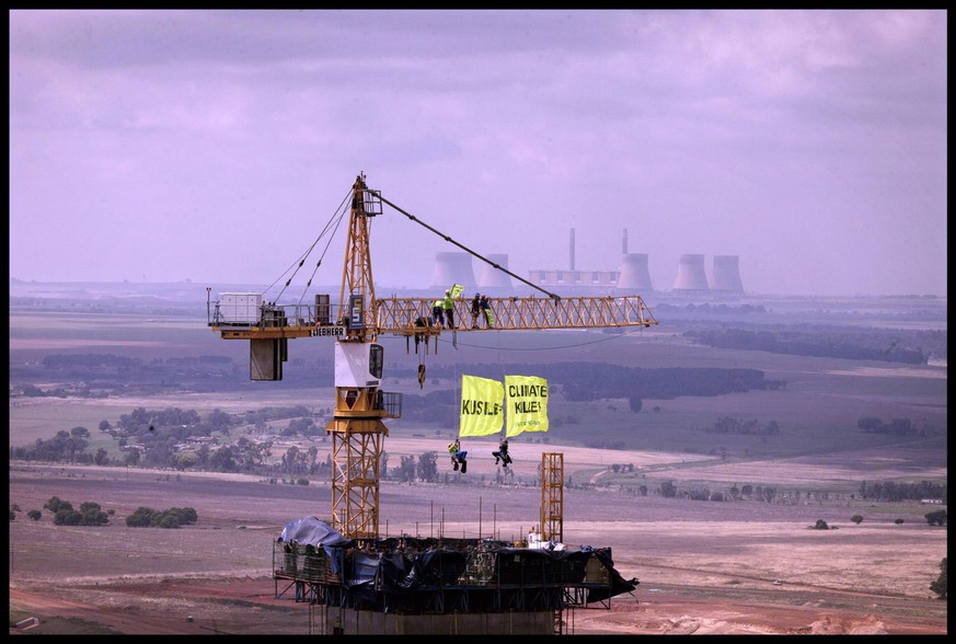 epa02995367 A hand out image released by Greenpeace 7 November 2011 shows Greenpeace activists hanging from a crane inside Eskom's Kusile power plant in the Delmas municipal area of the Mpumalanga pro ...