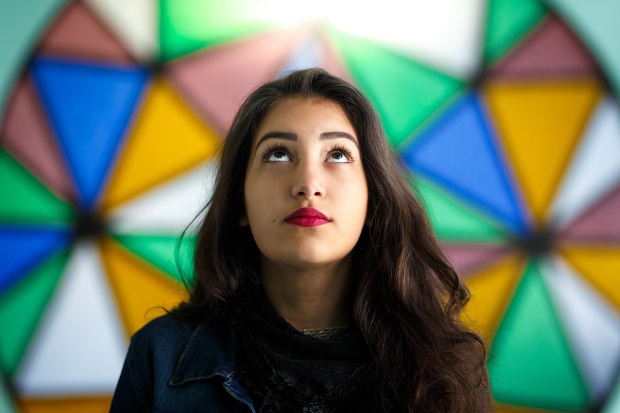 Girl looking up in front of a stained glass window