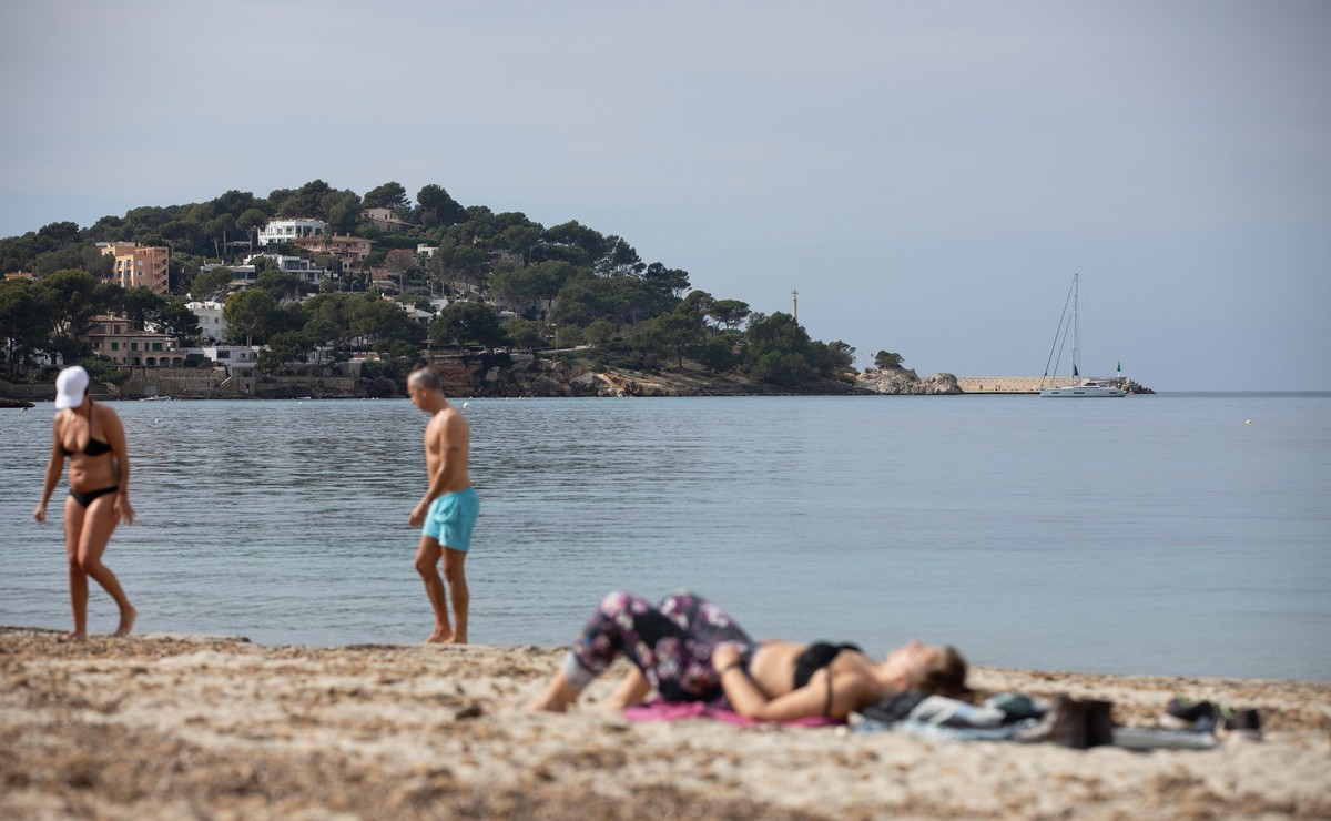 16.02.2025, Spanien, Calvia: Menschen sonnen sich am Strand von Santa Ponça. Die Temperaturen erreichen am Wochenende auf Mallorca maximal 20 Grad. Foto: Clara Margais/dpa +++ dpa-Bildfunk +++