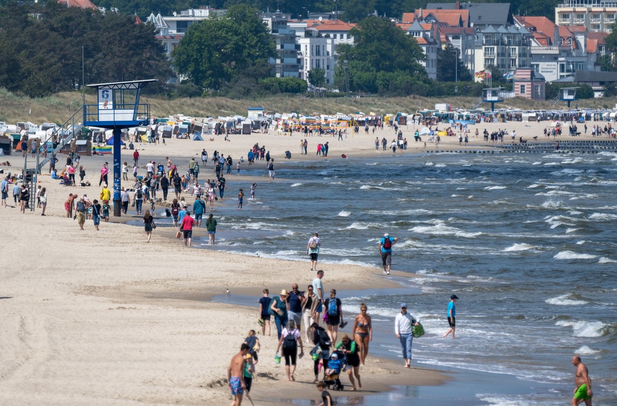 18.05.2024, Mecklenburg-Vorpommern, Heringsdorf: Spaziergänger sind bei sonnigem Wetter am Strand auf der Insel Usedom unterwegs. (zu dpa: «Pfingstwochenende in MV - für jeden etwas dabei») Foto: Stef ...