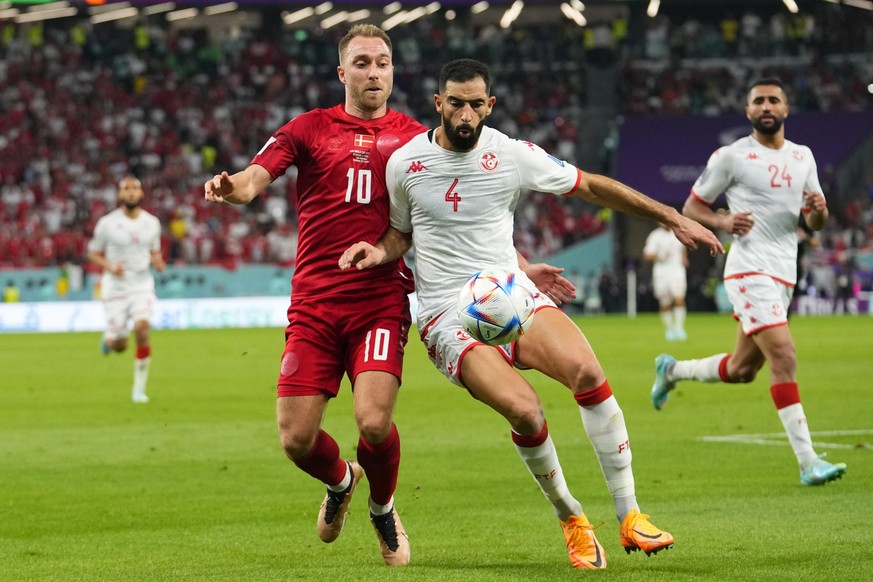 Denmark's Christian Eriksen, left, and Tunisia's Yassine Meriah vie for the ball during the World Cup group D soccer match between Denmark and Tunisia, at the Education City Stadium in Al Rayyan , Qat ...