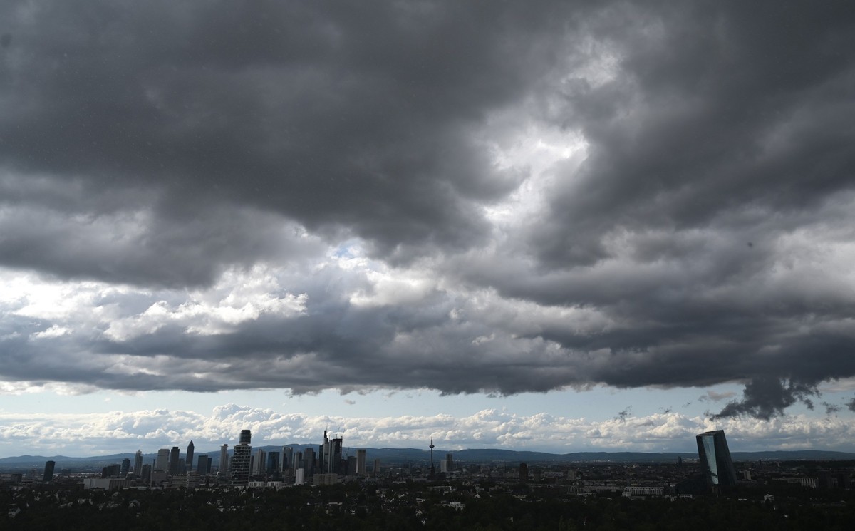 ARCHIV - 24.07.2023, Hessen, Frankfurt/Main: W�hrend dunkle Regenwolken am sp�ten Nachmittag �ber die Skyline der Bankenmetropole ziehen, klart es im Taunus (im Hintergrund) nach Schauern wieder auf. ...