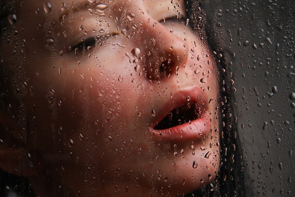 Naked girl in a wet glass on a black backgroundNaked girl in a wet glass on a black background