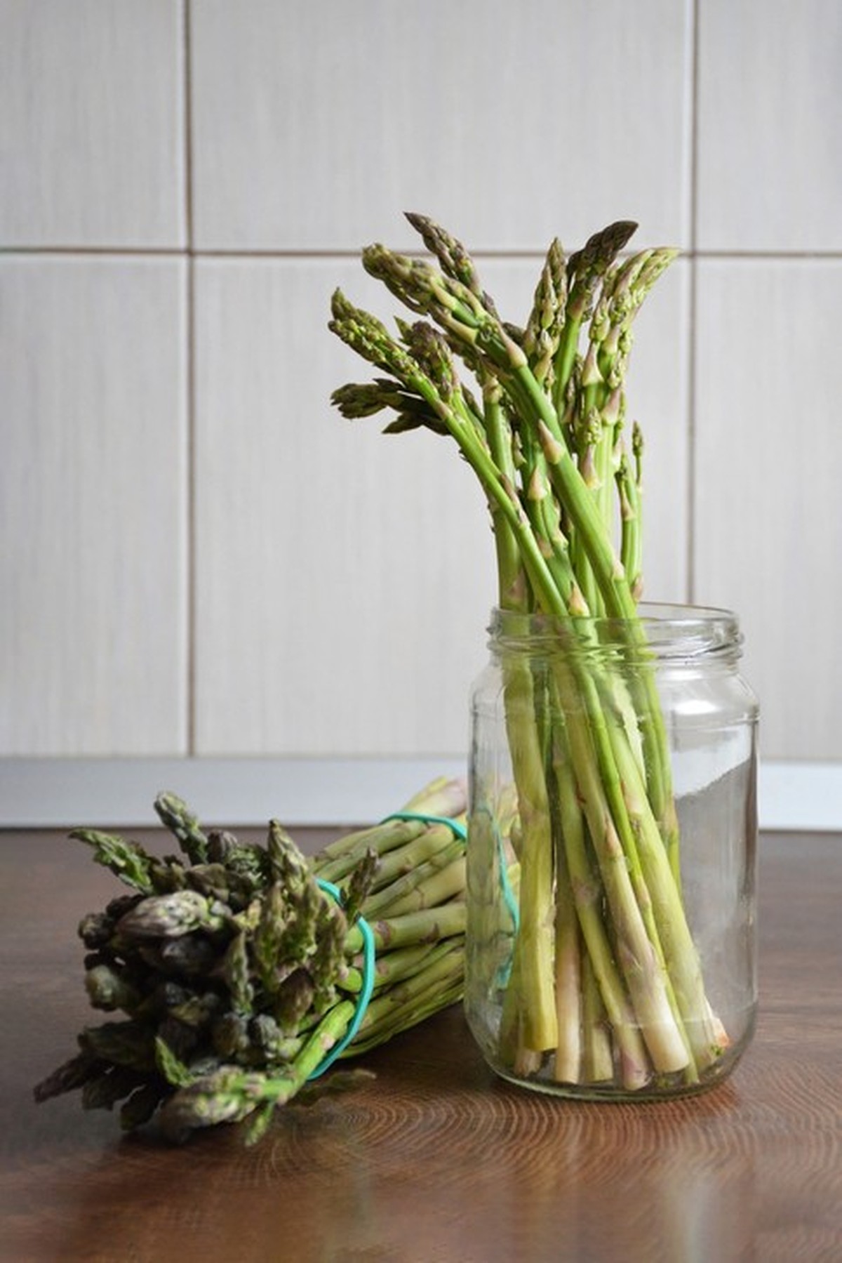 Bunches of green asparagus on kitchen board