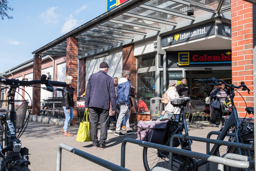 Ein Security-Mitarbeiter regelt den Einlass der Kunden vor dem Eingang einer Edeka-Filiale in Zehlendorf.