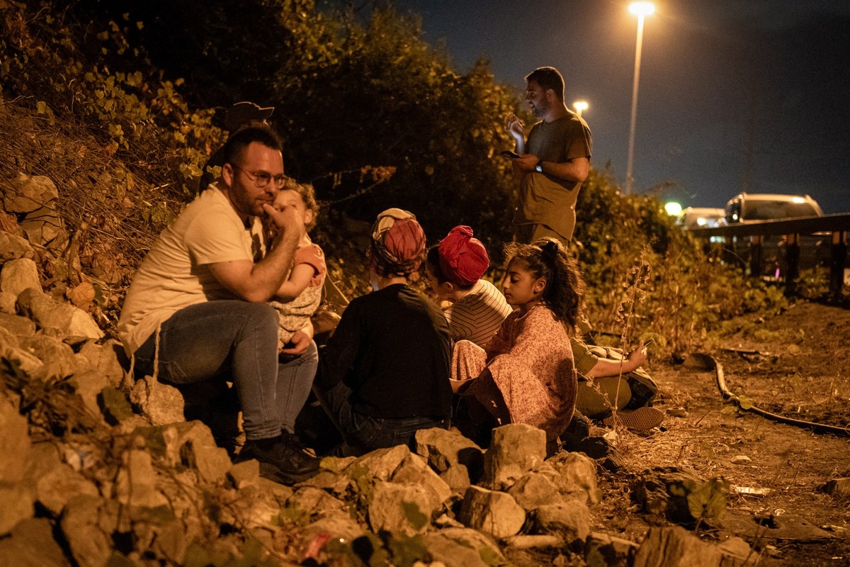 01.10.2024, Israel, Tel Aviv: Menschen gehen am Straßenrand in Tel Aviv in Deckung, während eine Warnung vor ankommenden Raketen aus dem Iran ausgegeben wird. Foto: Ilia Yefimovich/dpa +++ dpa-Bildfun ...