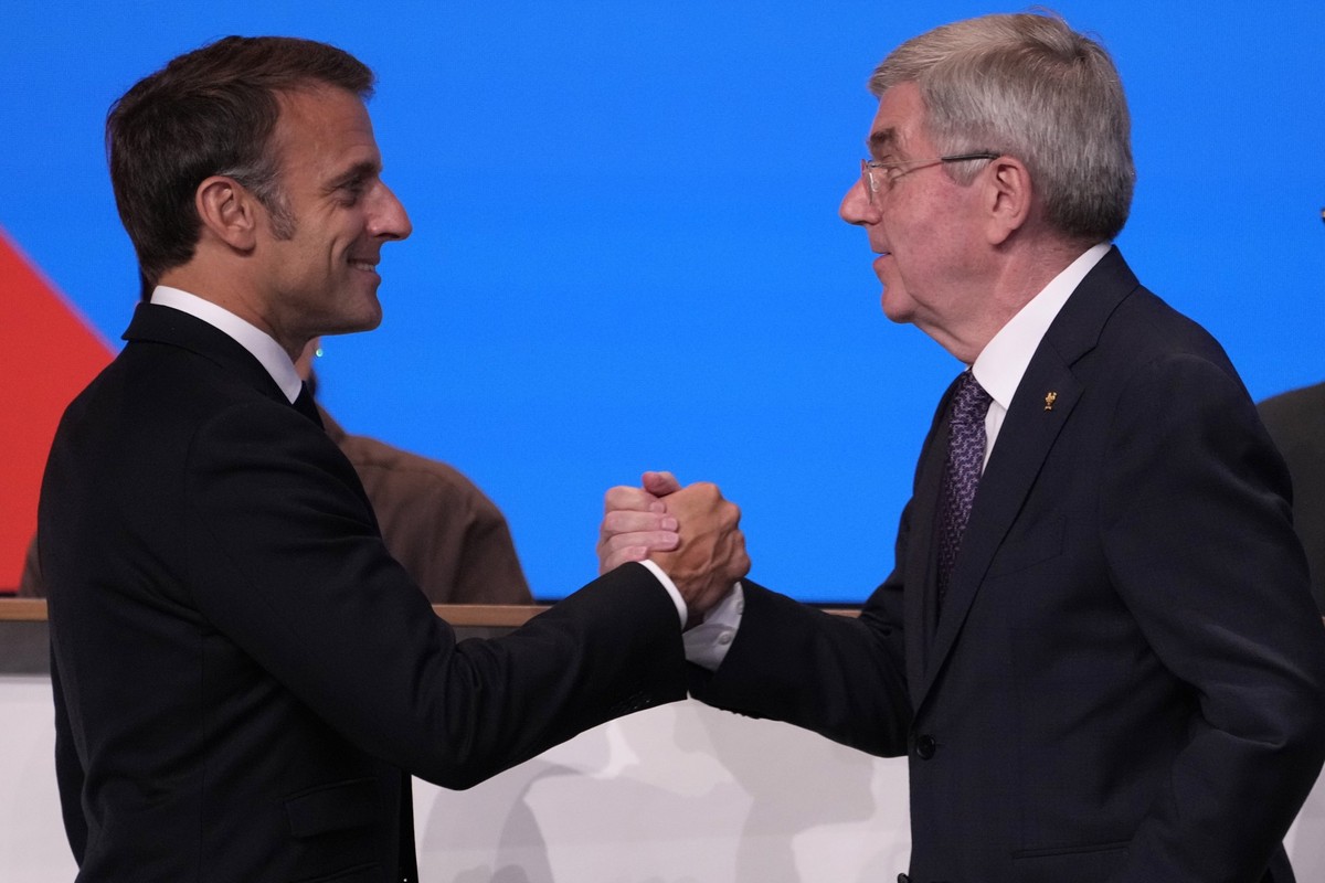 IOC president Thomas Bach, right, shakes hands to French President Emmanuel Macron after Bach announced that the French Alps was named as the 2030 Winter Games host at the 2024 Summer Olympics, Wednes ...
