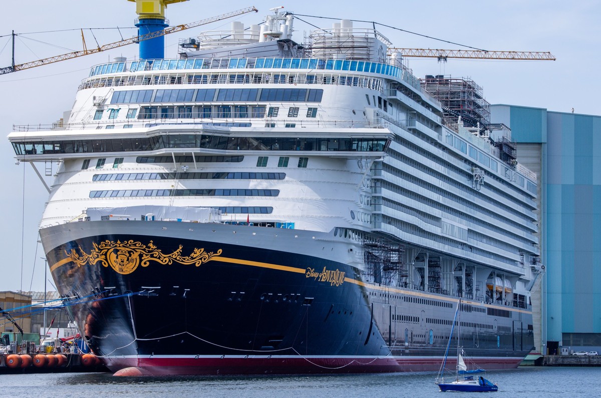 17.06.2025, Mecklenburg-Vorpommern, Wismar: Ein Segelboot fährt vor dem Kreuzfahrtschiff "Disney Adventure" am Ausrüstungskai der TKMS-Werft vorbei. Nach rund siebenjähriger Bauzeit wurde am ...