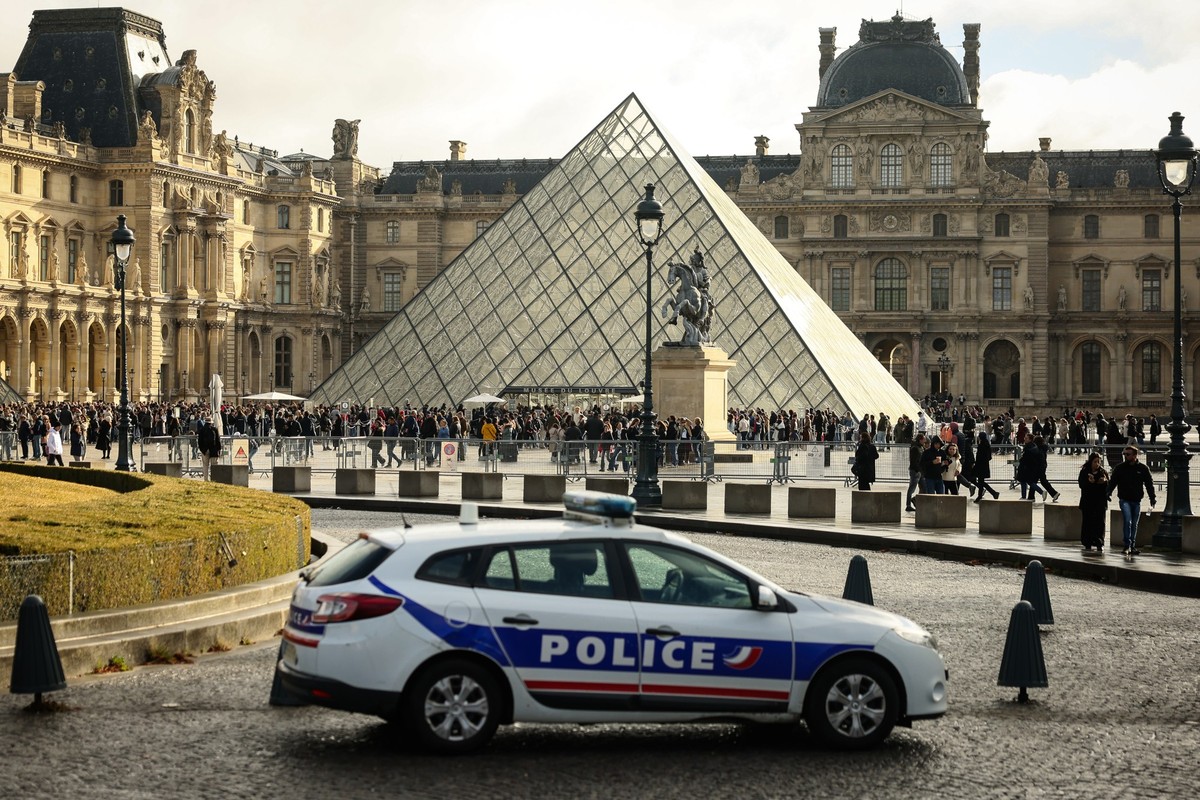 dpatopbilder - 26.10.2025, Frankreich, Paris: Ein Polizeiauto parkt im Hof des Louvre während Besucher vor der Glaspyramide in einer Schlange stehen. Eine Woche nach dem spektakulären Kunstraub im Par ...