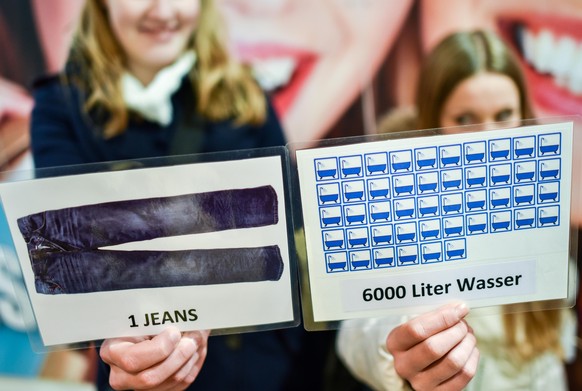 Schüler einer neunten Klasse halten am 27.11.2014 in Braunschweig (Niedersachsen) während einer konsumkritischen Stadtführung Zettel zum Wasserverbrauch in der Hand. Die Teilnehmer der Stadtführung so ...