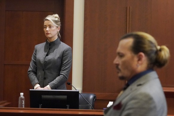 ARCHIV - 16.05.2022, USA, Fairfax: Amber Heard und Johnny Depp (r), beide Schauspieler aus den USA, sehen zu, wie die Jury den Gerichtssaal des Fairfax County Circuit Courthouse verl