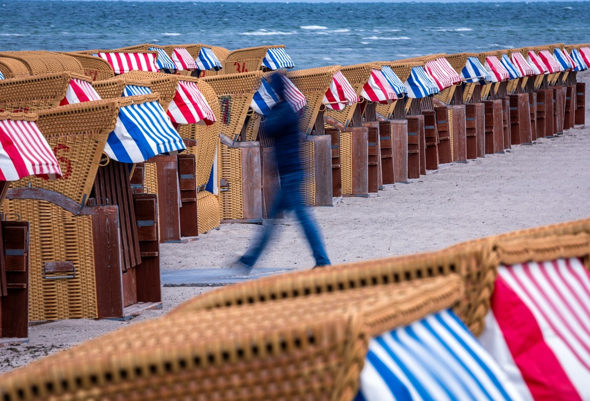 17.05.2023, Mecklenburg-Vorpommern, Timmendorf (poel): Nur wenige Spaziergänger sind zwischen leeren Strandkörben an der Ostseeküste auf der Insel Poel unterwegs. (Aufnahme mit langer Belichtungszeit) ...