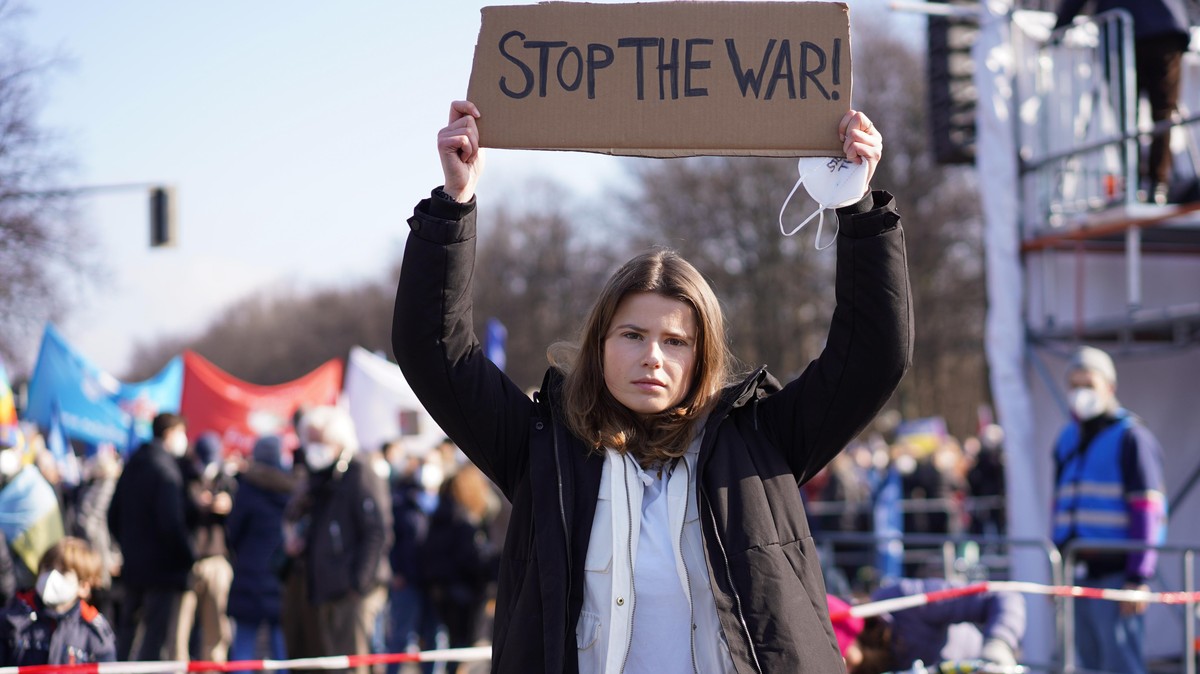 Klimaaktivistin Luisa Neubauer hält ein Schild &quot;Stop the war!&quot; vor einer Demonstration unter dem Motto &quot;Stoppt den Krieg! Frieden für die Ukraine und ganz Europa&quot; gegen den russisc ...