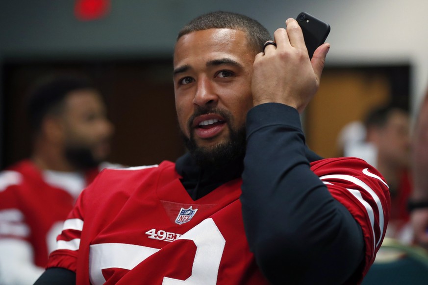 San Francisco 49ers outside linebacker Mark Nzeocha, of Germany, listens to his phone after an interview during a media availability, Wednesday, Jan. 29, 2020, in Miami, for the NFL Super Bowl 54 foot ...