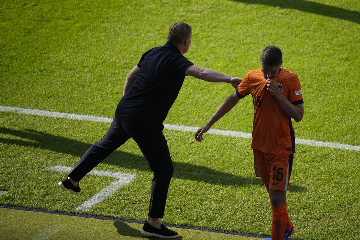 Joey Veerman of the Netherlands, right, receives a pat from head coach Ronald Koeman during a Group D match between the Netherlands and Austria at the Euro 2024 soccer tournament in Berlin, Germany, T ...