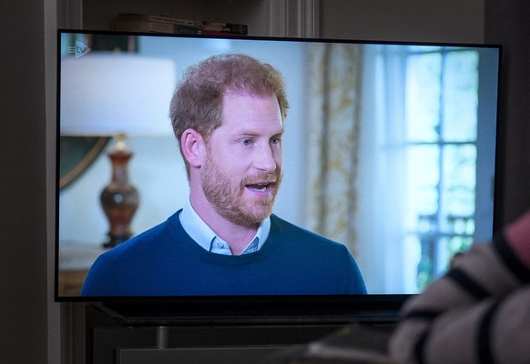 08.01.2023, Gro�britannien, Edinburgh: Eine Person, die zu Hause in Edinburgh beobachtet, wie Prinz Harry, der Herzog von Sussex, von ITV zu �Harry: Das Interview� interviewt wird, zwei Tage vor der V ...