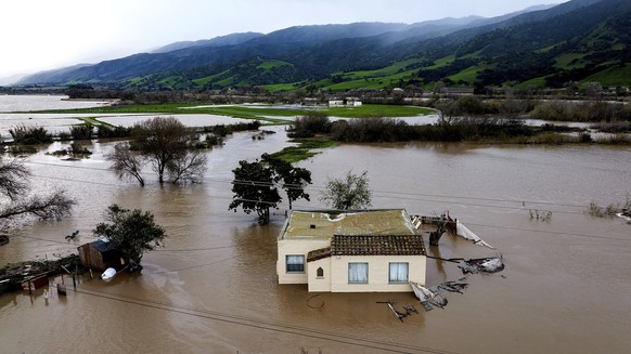 13.01.2023, USA, Chualar: Hochwasser umgibt ein Haus, nachdem der Salinas River über die Ufer trat. Kalifornien erlebt derzeit eine dritte Woche schwerer Winterstürme mit starkem Regen, heftigen Winde ...