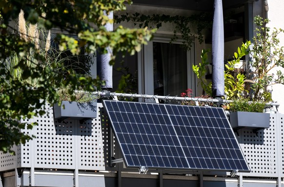 ARCHIV - 22.09.2022, Bayern, M�nchen: Eine kleine Solaranlage ist an einem Balkon eines Mehrparteienhauses angebracht. (zu dpa: �FDP fordert leichtere Genehmigungsverfahren f�r Balkon-Solaranlagen�) F ...