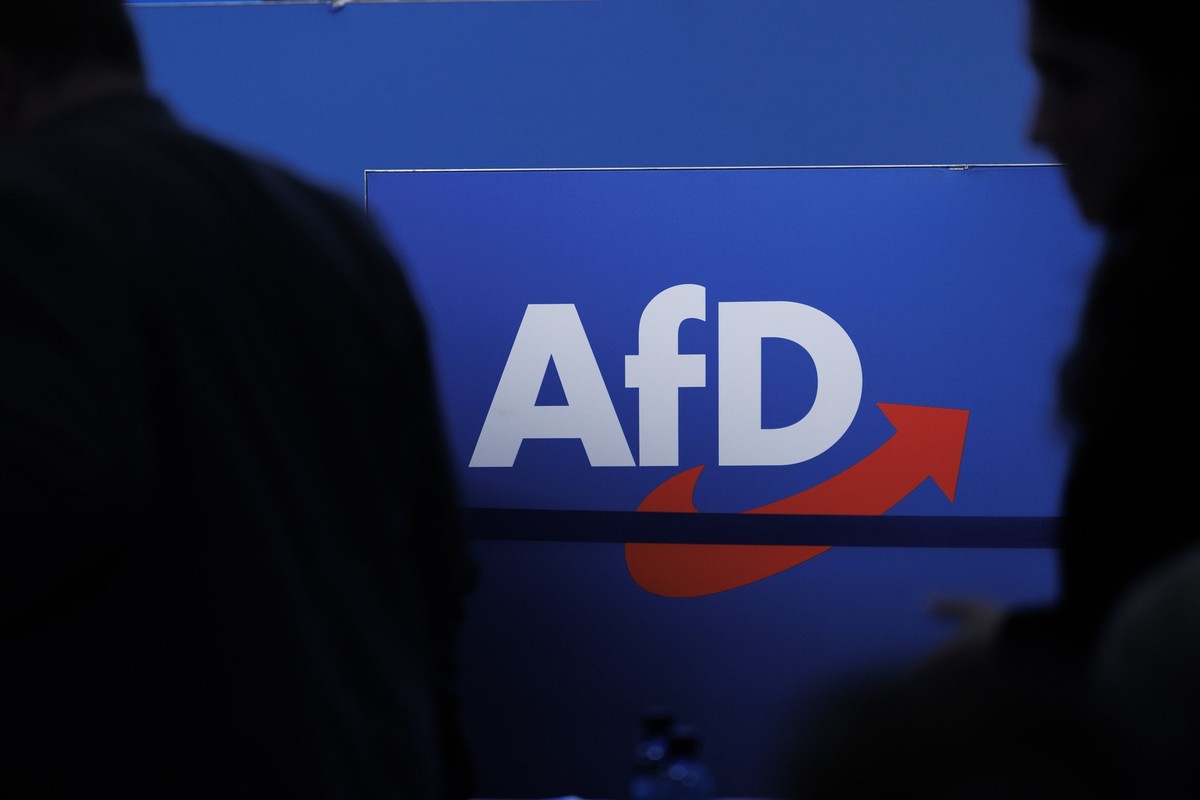 ARCHIV - 28.07.2023, Sachsen-Anhalt, Magdeburg: Delegierte gehen vor dem Parteilogo bei dem AfD-Bundesparteitag in Magdeburg. (zu dpa: «Verfassungsschutz: AfD ist gesichert rechtsextremistisch») Foto: ...