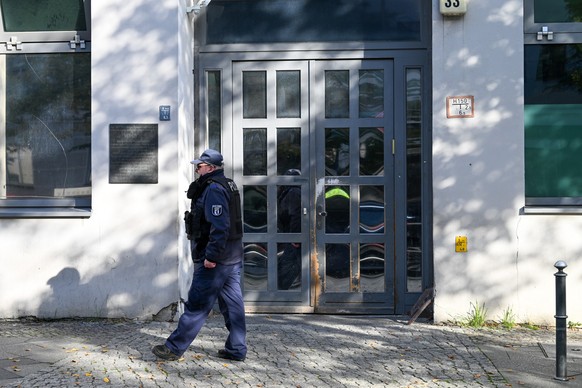 18.10.2023, Berlin: Ein Polizeibeamter geht an der Synagoge an der Brunnenstraße 33 in Berlin entlang, die Ziel eines Anschlags war. Nach dem versuchten Brandanschlag auf eine Synagoge in Berlin haben ...