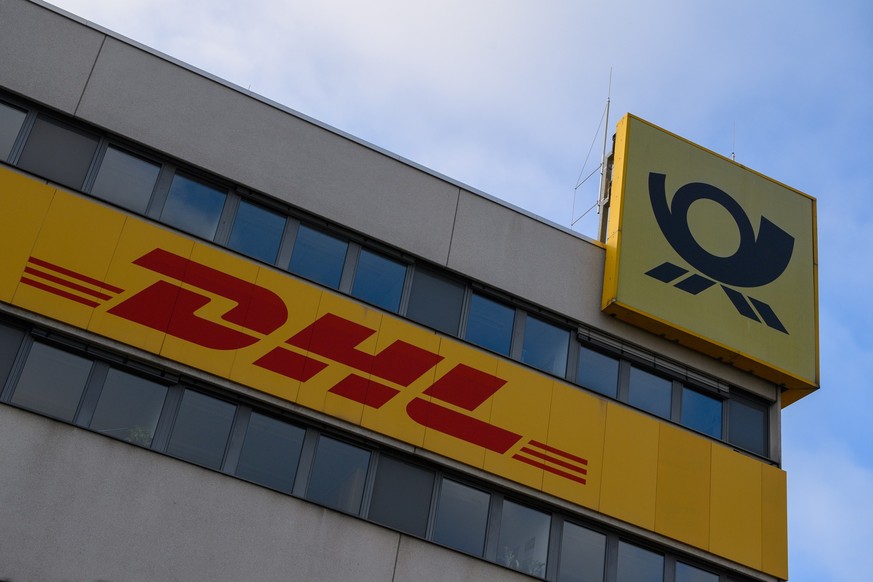 PRODUKTION - 21.11.2022, Sachsen-Anhalt, Magdeburg: &quot;DHL&quot; und das Logo der Deutschen Post ist an der Fassade des DHL Paketzentrums zu sehen. Die Post bereitet sich derzeit auf Weihnachten vo ...