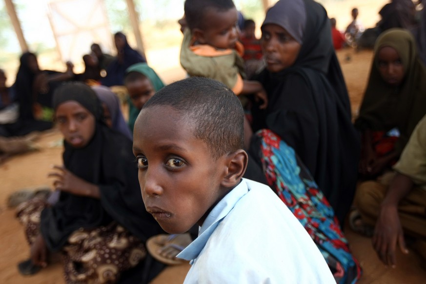 Dadaab, Kenya - August 13, 2011: A newly arrived Somali refugees waits following their registration and food on August 13, 2011 at the Dadaab refuge complex. UN Under-Secretary-General for Humanitaria ...