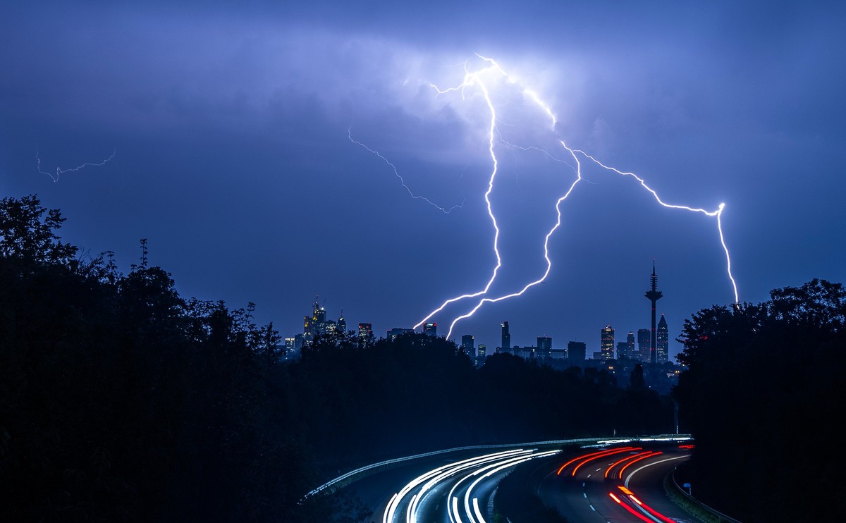 ARCHIV - 12.09.2023, Hessen, Frankfurt/Main: Blitze sind während eines Gewitters über der Skyline von Frankfurt am Main und der Autobahn A661 zu sehen. (zu dpa: «Schwülwarme Temperaturen und Gewitter- ...