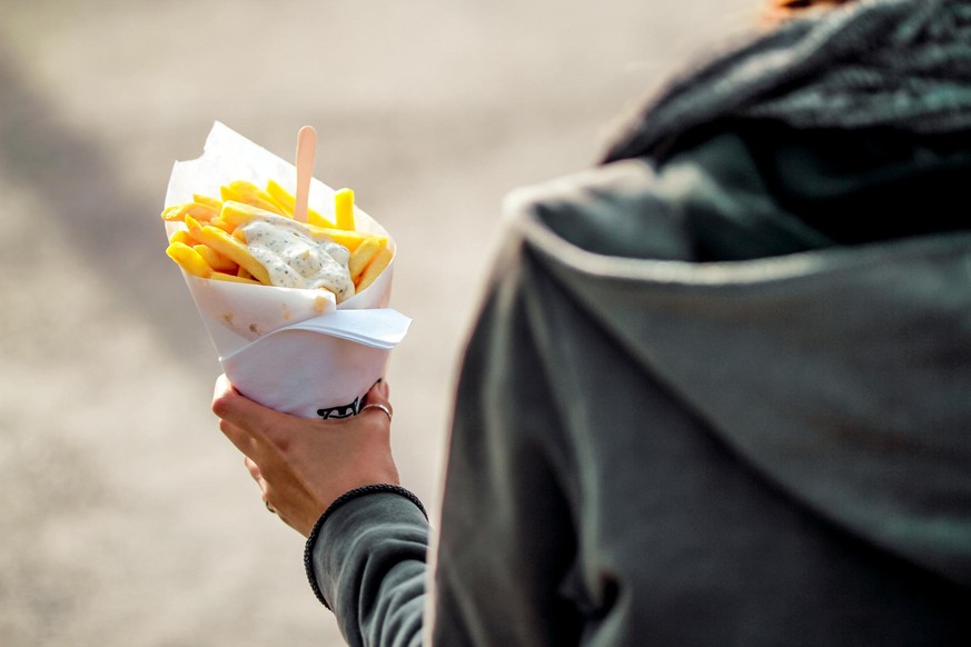 Frau mit einer Tüte Pommes Frittes.