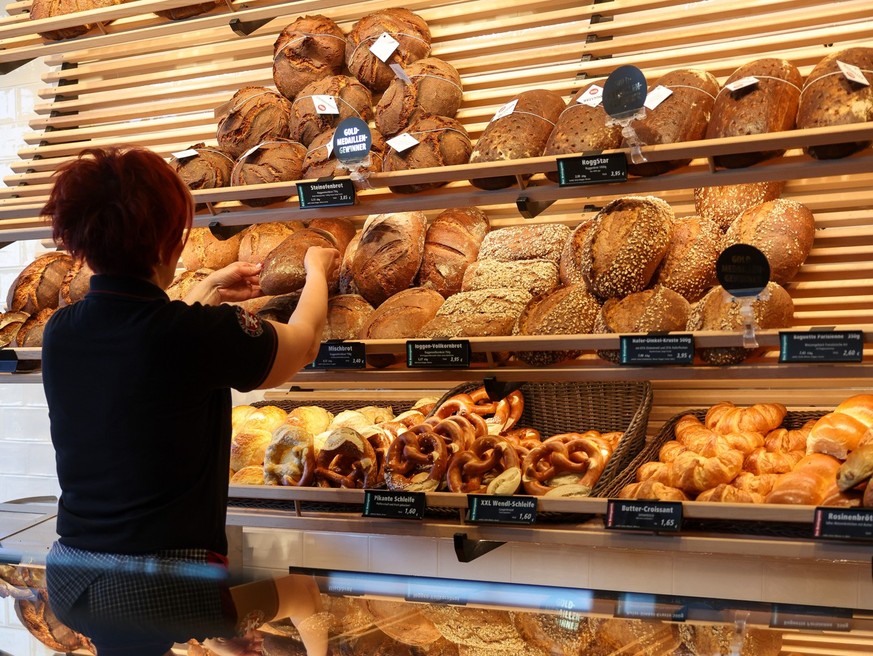 26.06.2023, Sachsen, Leipzig: Eine Mitarbeiterin räumt Mischbrot in die Auslage einer Bäckerei. Am gleichen Tag gibt die Mindestlohnkommission ihren Vorschlag für den Mindestlohn 2024 bekannt. Foto: J ...