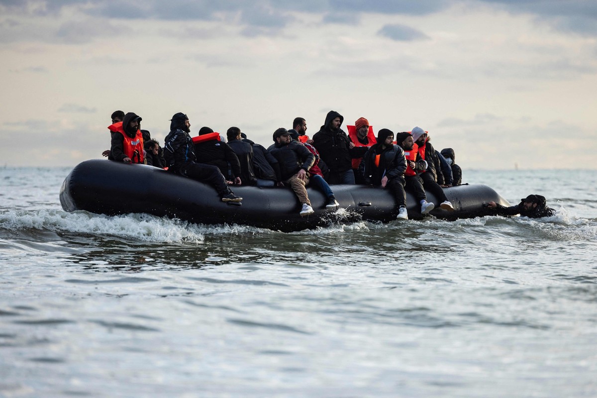 ARCHIV - 26.04.2024, Frankreich, Loon-Plage: Migranten sitzen auf einem Schlauchboot und versuchen, den