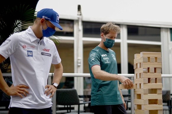 Konzentriert spielen Mick Schumacher (l.) und Sebastian Vettel das Geschicklichkeitsspiel Jenga