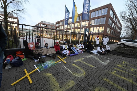 13.01.2023, Nordrhein-Westfalen, Essen: Umweltaktivisten haben sich an das Tor der Hauptzentrale des Energieversorgers RWE angekettet, um gegen die Räumung von Lützerath im Kohleabbaugebiet zu protest ...