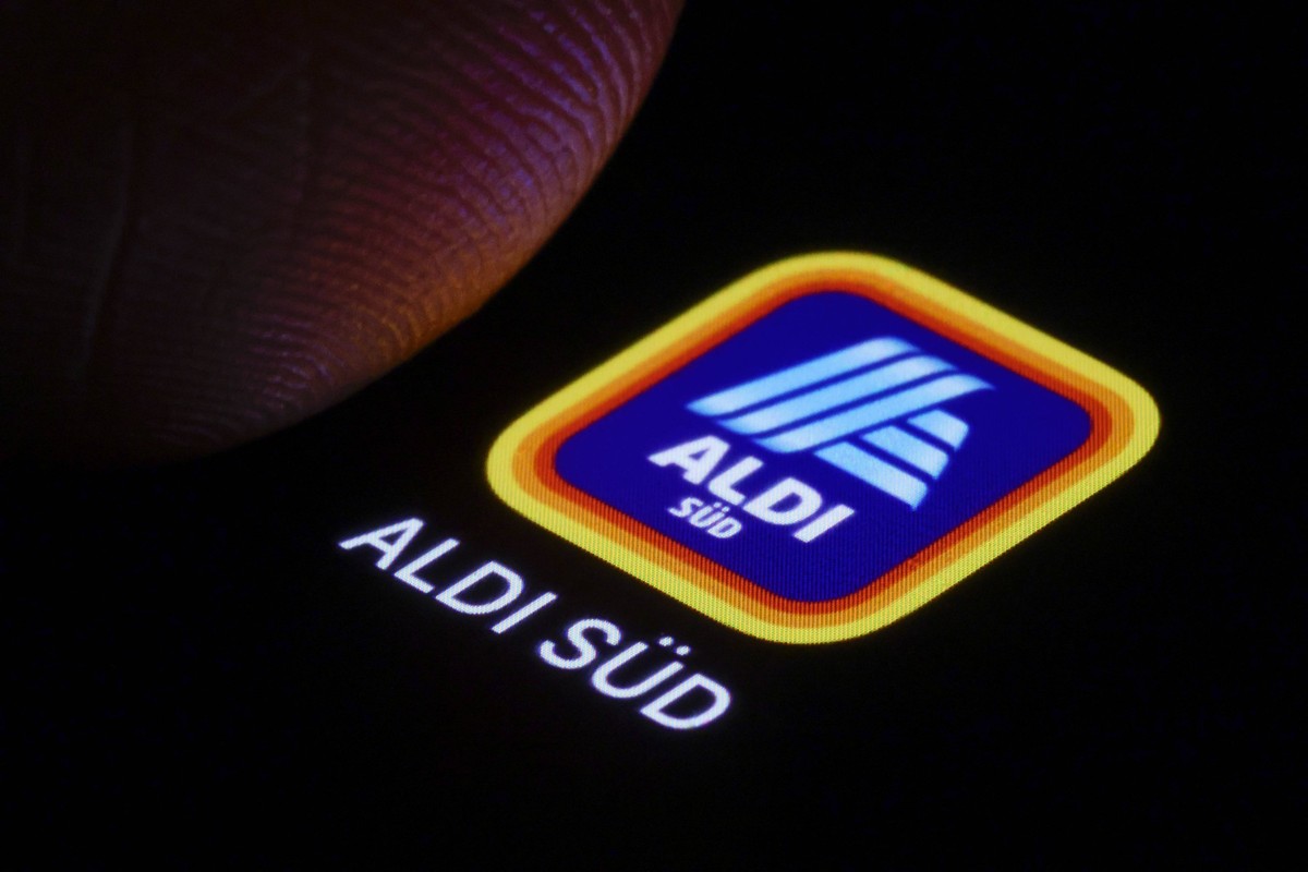 Das Logo der ALDI SUED App ist neben einem Finger auf einem Smartphone zu sehen. Berlin, 03.01.2025. Berlin Deutschland *** The logo of the ALDI SUED app can be seen next to a finger on a smartphone B ...