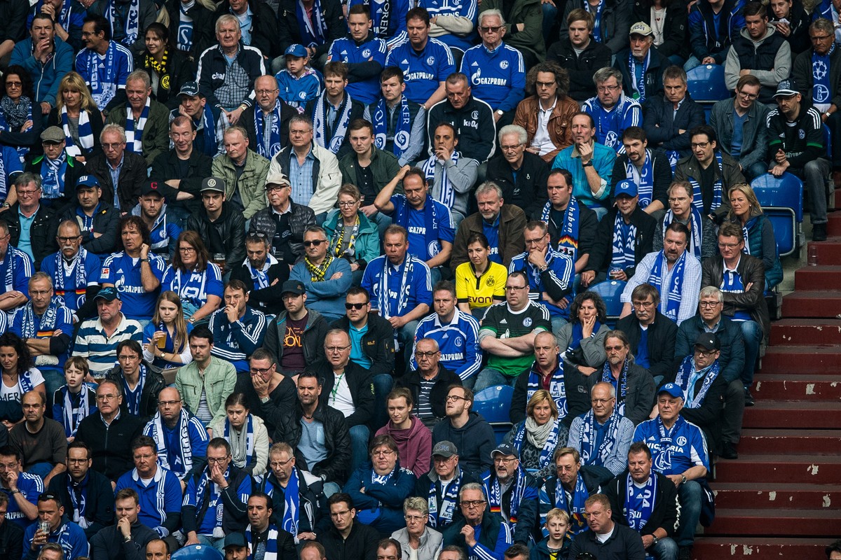 GELSENKIRCHEN, GERMANY - APRIL 01: A fan of Dortmund sits between a lot of fans of Schalke during the Bundesliga match between FC Schalke 04 and Borussia Dortmund at Veltins-Arena on April 1, 2017 in ...